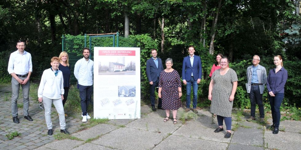 Haus der Befreiung - Gruppenbild mit der Tafel zur Geschichte und zum Umbau