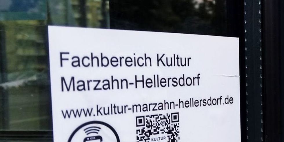 Fotos eines Informationsplakates im Fenster einer Einrichtung mit Hinweisen zum NFC-Chip und mit QR-Code zum Abruf von Informationen vor Ort