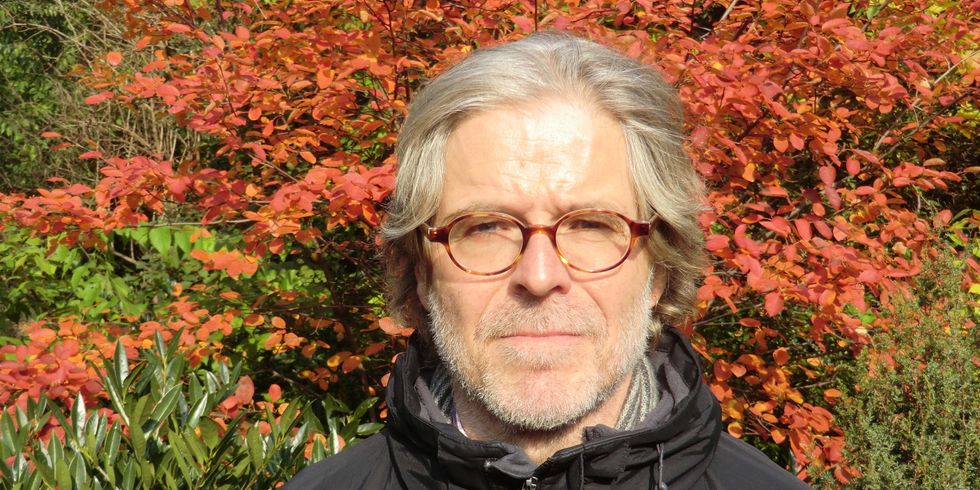 Foto von Reinhard Griebner vor einem roten Busch