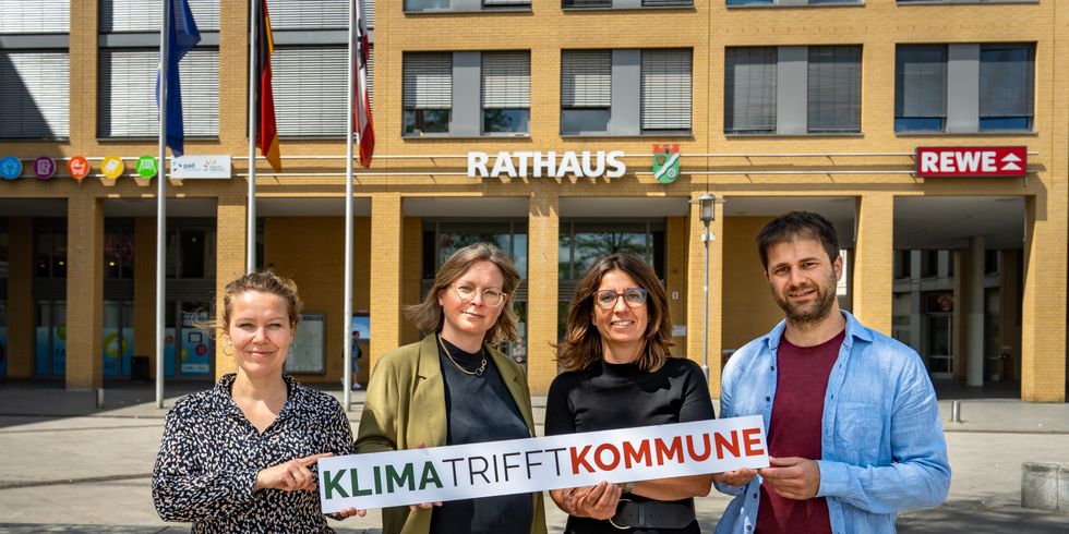 Bezirksbürgermeisterin Nadja Zivkovic mit Vertreterinnen der Projektpartner und dem Klimaschutzbeauftragten halten ein Schild mit der Aufschrift "Klima trifft Kommune"