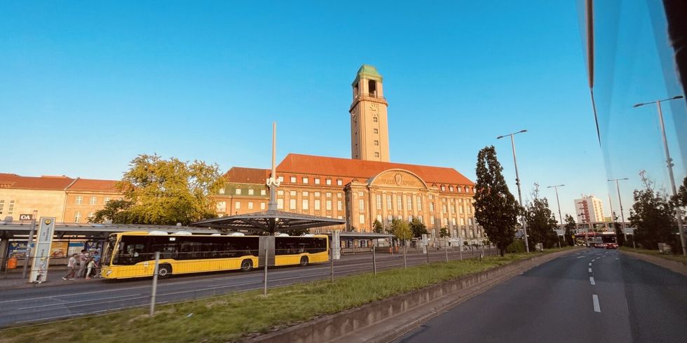 Ein gelber BVG-Bus hält direkt vor dem Rathaus Spandau