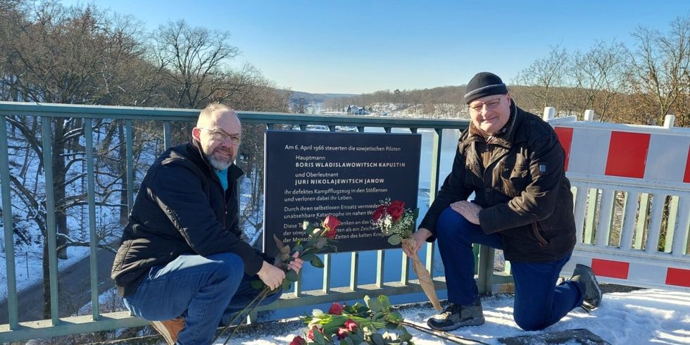 Der Vorsteher und ein Bezirksverordneter legen Blumen an der Gedenktafel nieder