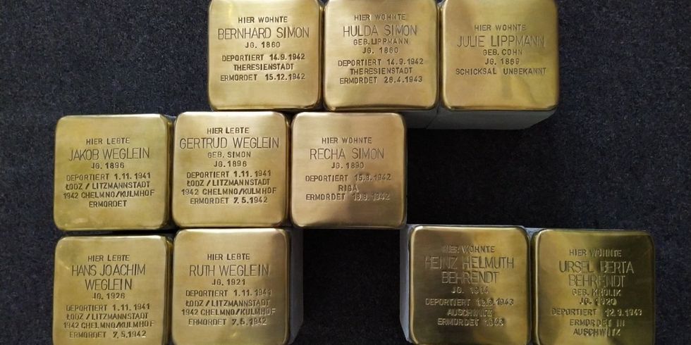 Zehn goldene Stolpersteine mit Namen und Daten zu verschiedenen Personen liegen nebeneinander.