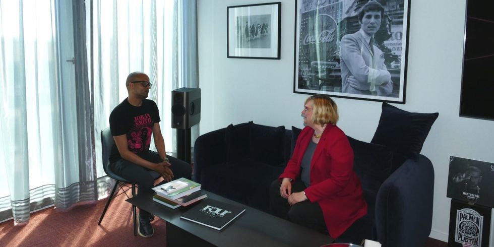 Eine Frau und ein Mann sitzen an einem Tisch und reden miteinander.