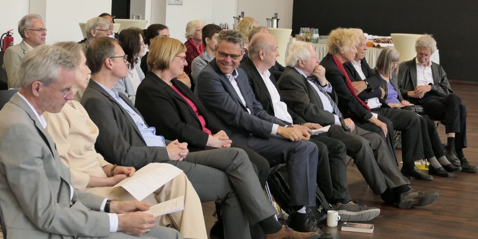 Elf Erwachsene sitzen in einer Reihe