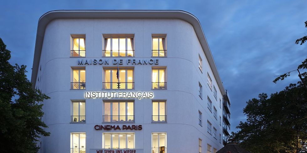Ein vierstöckiges Gebäude frontal und innen beleuchtet