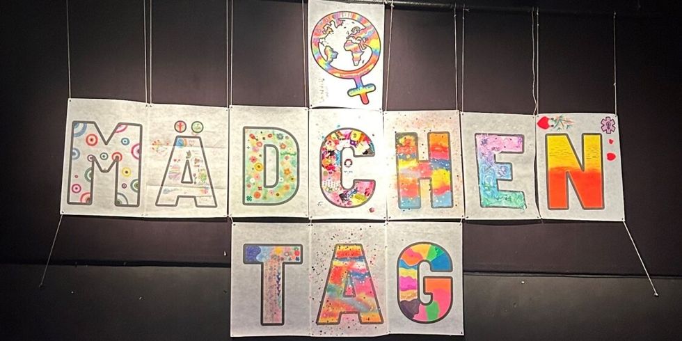 aufgehängte bunte Schilder mit dem Schriftzug "Mädchentag"
