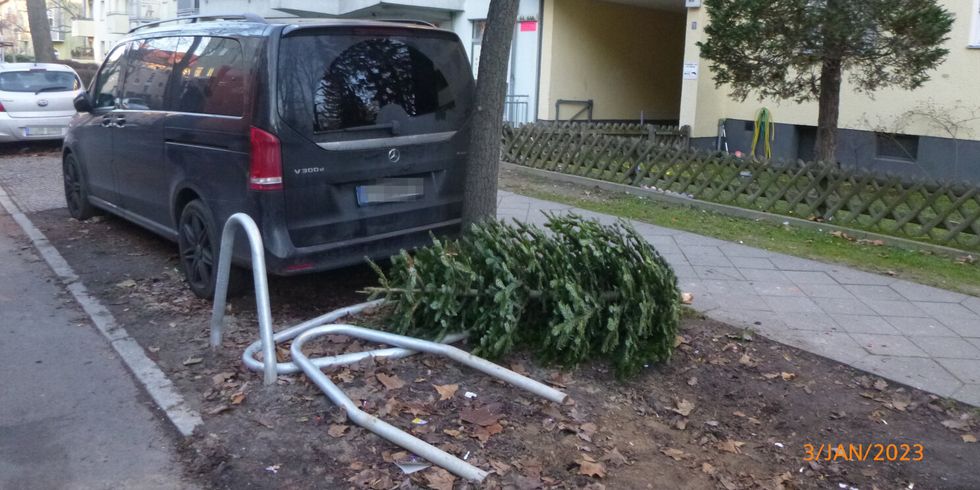 ein Auto steht dicht an einem Baum. Daneben liegen herausgezogenen Absperrungen.