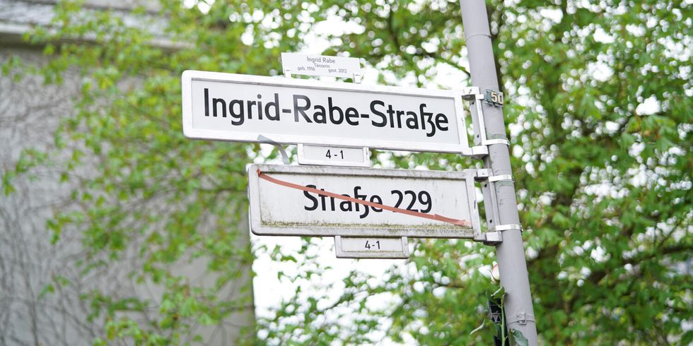 Ein doppeltes Straßenschild; oben steht Ingrid-Rabe-Straße und unten steht Straße 229 durchgestrichen.