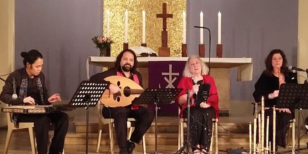 vier Menschen mit Musikinstrumenten sitzen auf Stühlen im Halbkreis