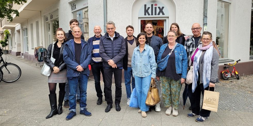 Eine Gruppe Menschen steht zusammen vor einem Laden mit dem Namen Klix.
