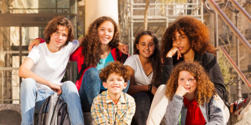 Eine Gruppe sitzender Kindern und Jugendlicher