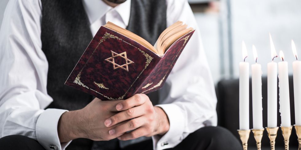 Ausgeschnittene Ansicht eines jüdischen Mannes, der in seiner Wohnung Tanach