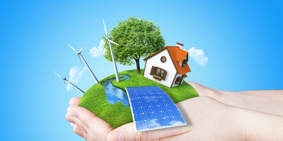 Die Hände halten klar grüne Wiese mit Batterie, Solarmodul, Mühle, Windkraftanlagen und Haus. Konzept für Ökologie, alternative Energie, frische, Freiheit. grün