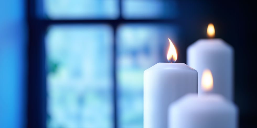 Brennende Kerze vor Fenster
