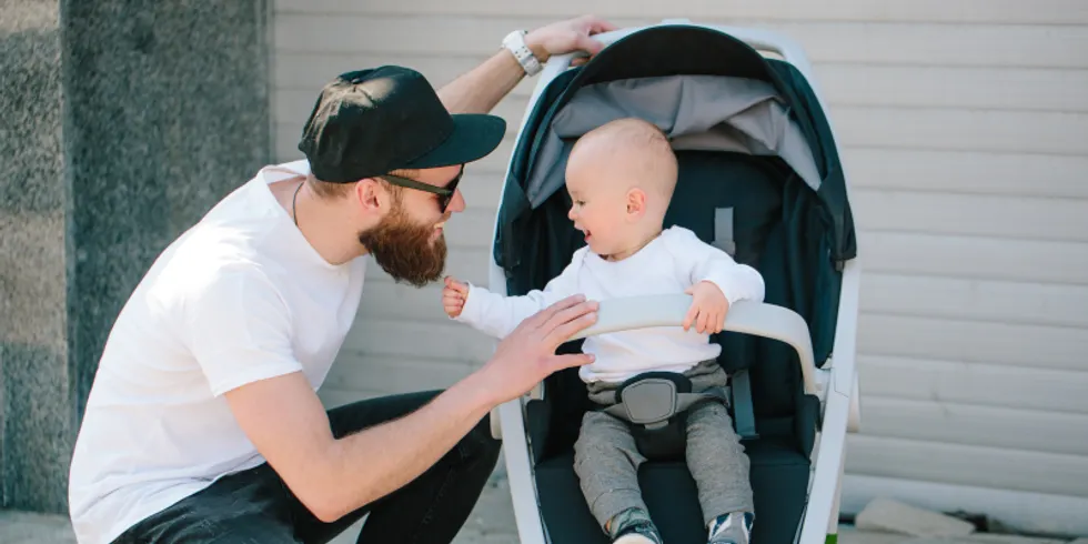 Vater mit einem Kinderwagen und ein Baby in den Straßen der Stadt zu Fuß
