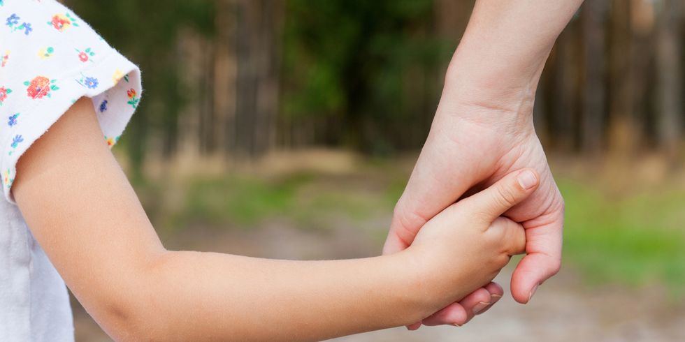 Mutter hält die Hand ihres Kindes
