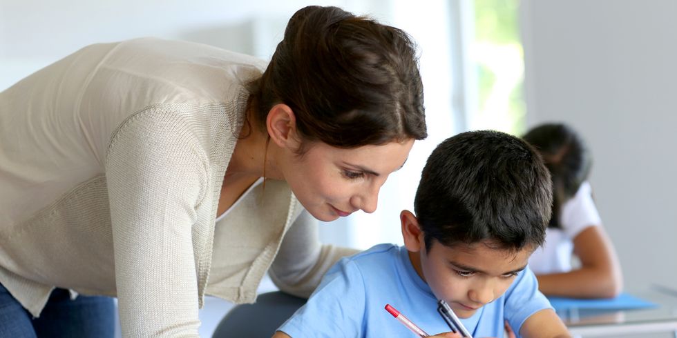 Lehrerin hilft kleinem Jungen bei den Hausaufgaben