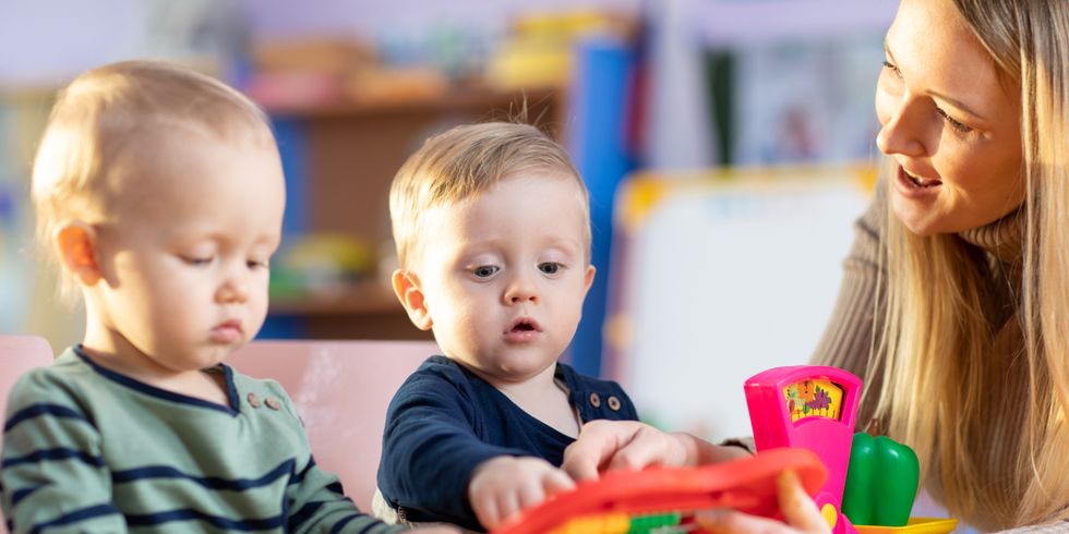 Erzieherin spielt mit zwei Kindern