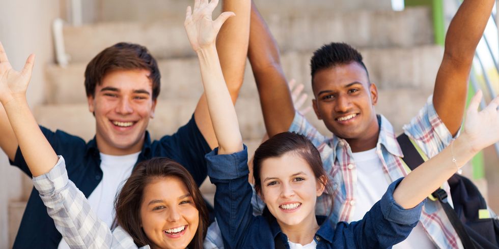 Fröhliche Schüler mit ausgestreckten Armen