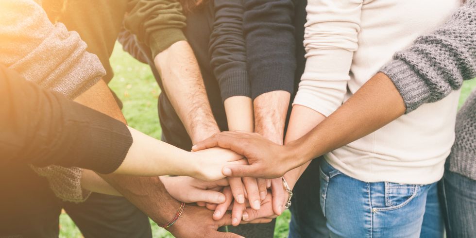 Freundesgruppe hält Hände in der Mitte zusammen