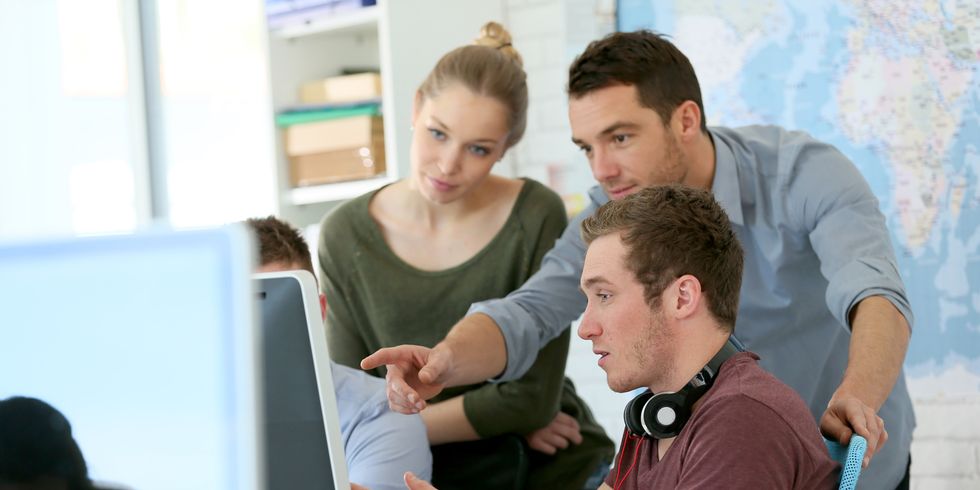 Gruppe junger Menschen arbeitet gemeinsam an einem Rechner