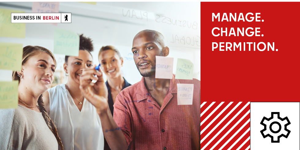 Four people writing on a glass wall (managing a business)