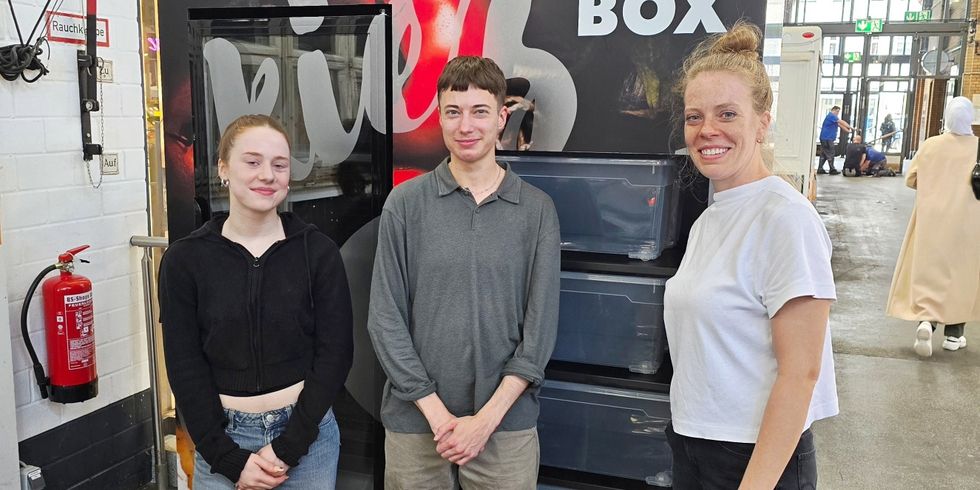 Drei Personen stehen vor der sog. Kiezbox, einem großen Kühlschrank für Lebensmittelrettung