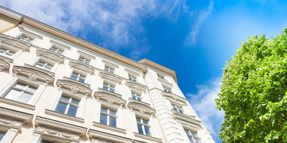 Fassade eines Berliner Altbaus, davor steht ein Baum
