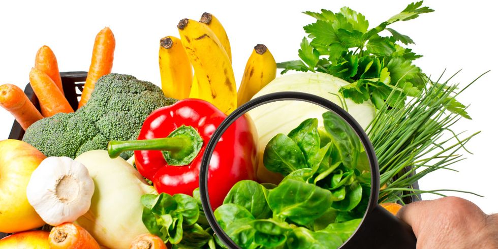 Lebensmittelkontrolle bei Obst und Gemüse mit einer Lupe