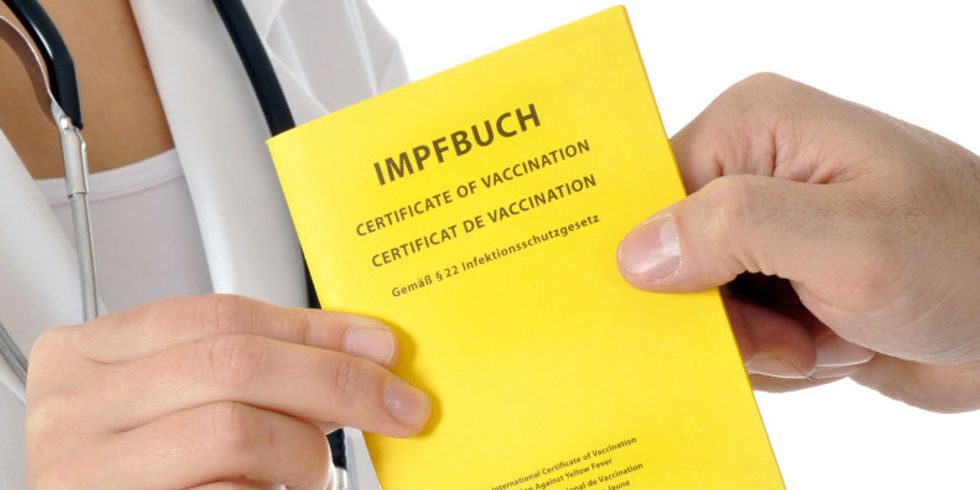 Patient übergibt Impfpass an Arzt