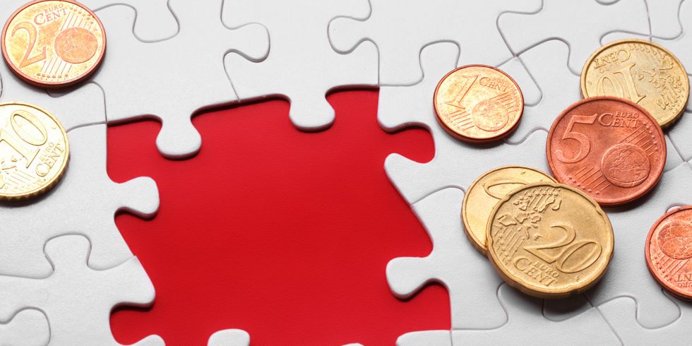 Geldstücke auf Puzzleteilen