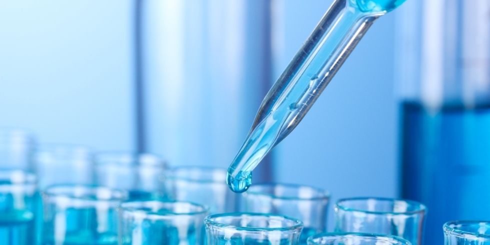 Flüssigkeit, die mit einer Pipette in mehrere Reagenzgläser gefüllt wird