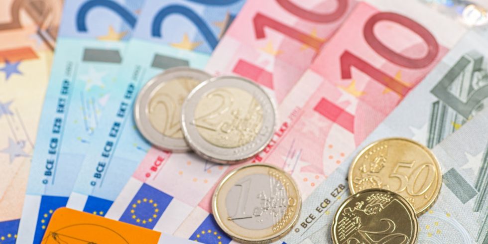 Auf verschiedenen Geldscheinen liegen Kleingeld und eine Krankenkassenkarte