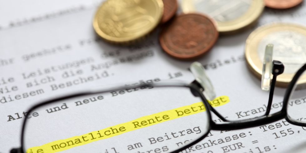 Eine Brille und Münzen liegen auf einem Rentenbescheid