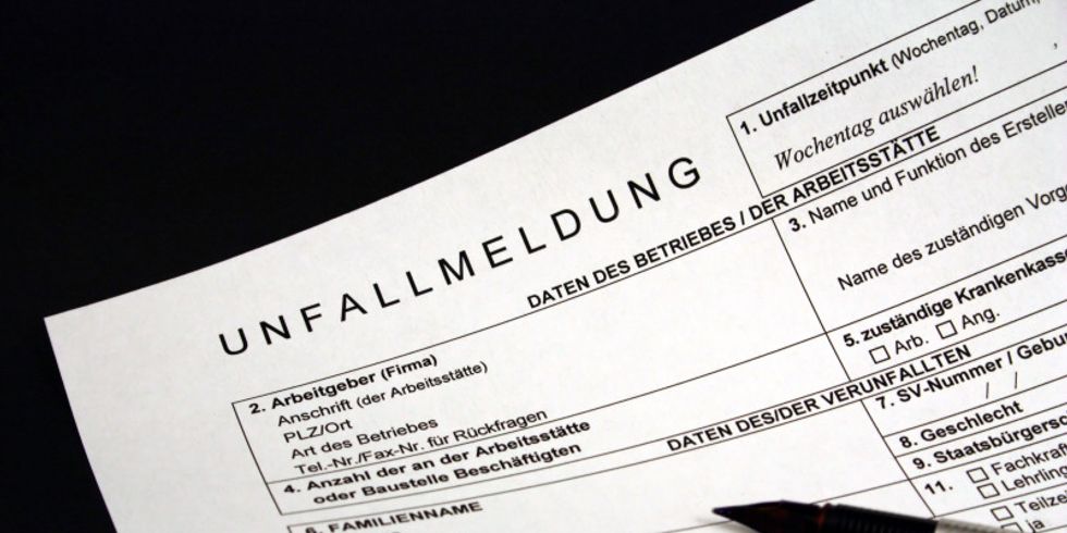Unausgefülltes Unfallmeldungsformular mit daraufliegendem Stift