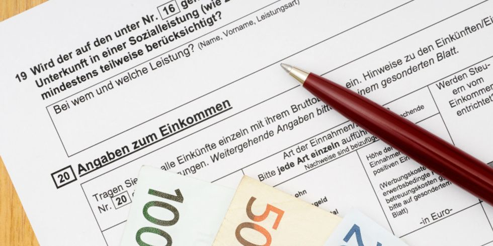 Geldscheine und ein Stift liegen auf einem Wohngeldantrag