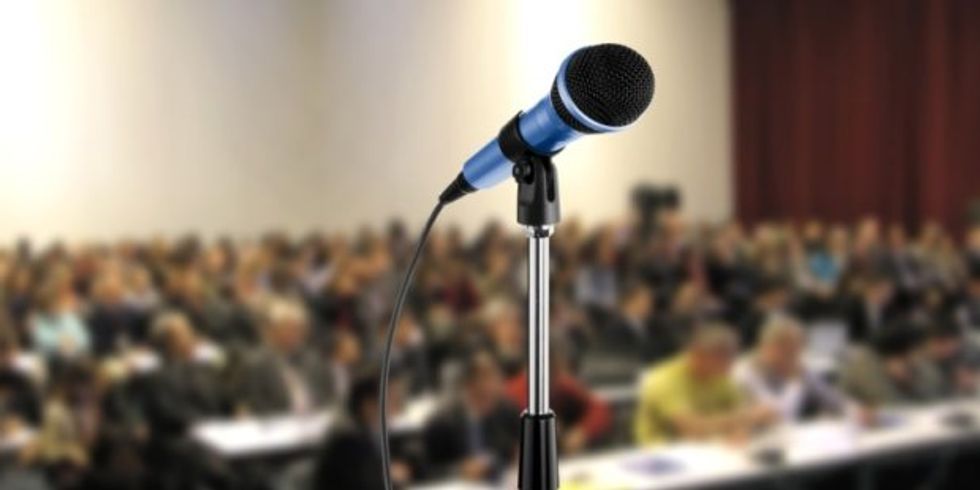 Mikrofon vor einem Hörsaal mit Menschen