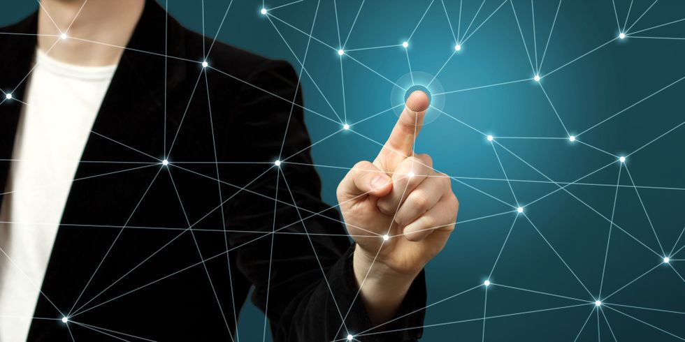 Person tippt mit dem Zeigefinger auf einen Knotenpunkt eines Netzwerks