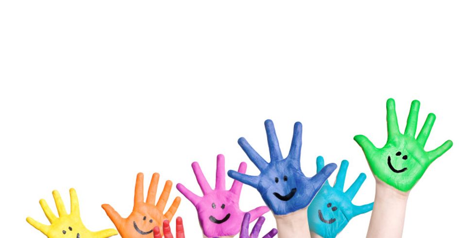 lachende Kinderhände in regenbogenfarben