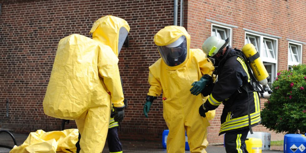 Drei Feuerwehrleute in Schutzanzügen