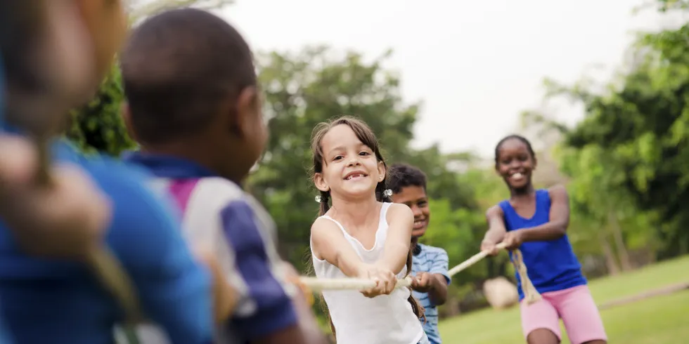 Kinder ziehen von zwei Seiten an einem Seil