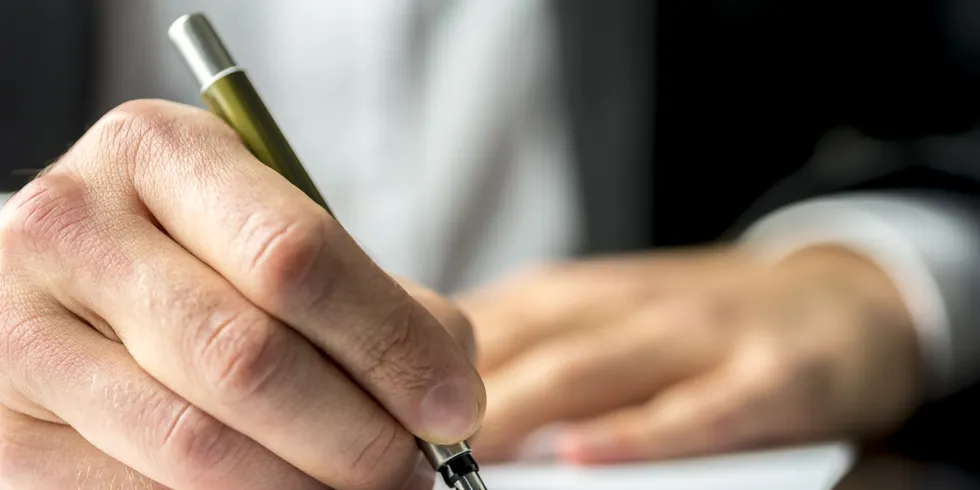 Hand bei Unterschrift Notiz Vertrag