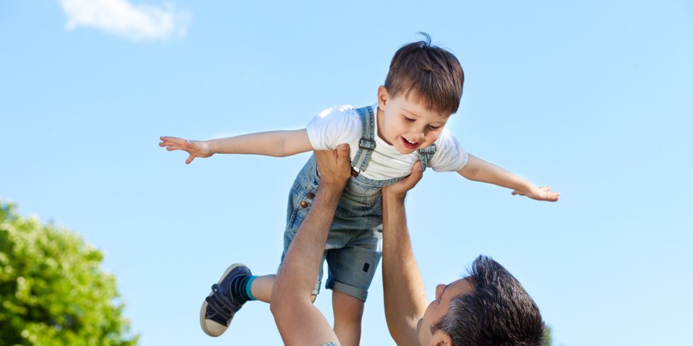 Vater wirft Sohn mit Freude in die Luft