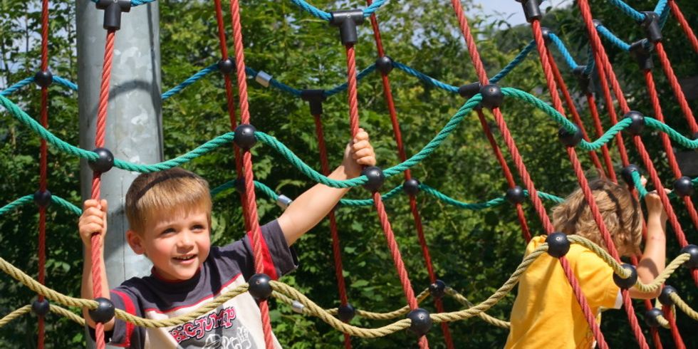 Kinder klettern auf Spielgerüst