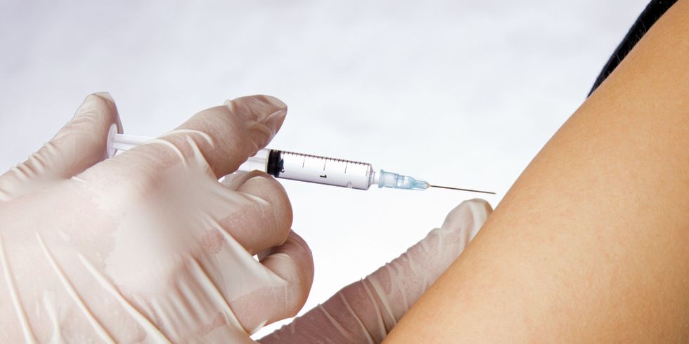 Mediziner verabreicht Spritze an einem Arm
