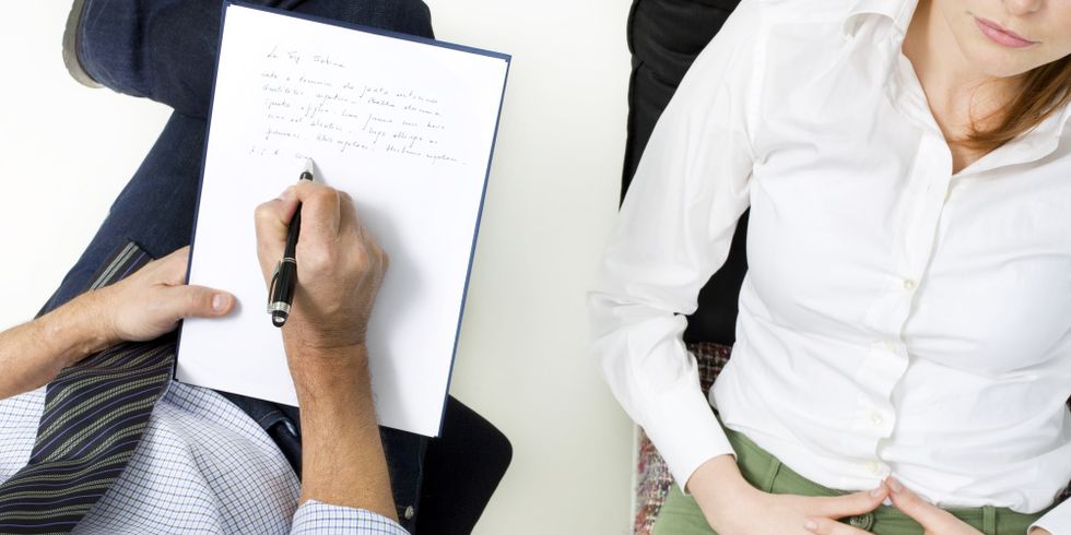 Ein Psychiater macht sich Notizen während er mit einer Patientin spricht