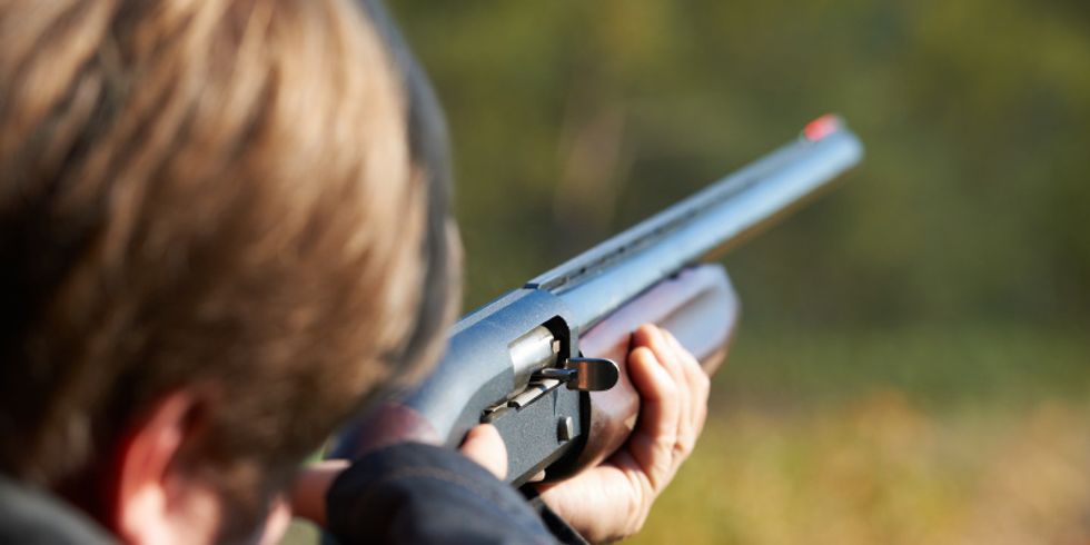 Eine Person zielt mit einem Gewehr