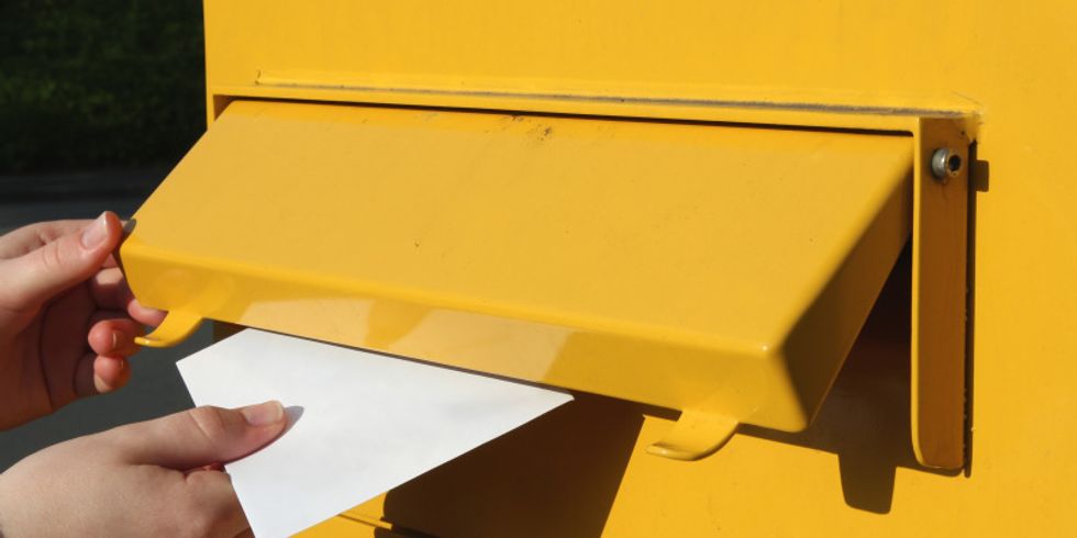 Brief wird in einen Briefkasten eingeworfen