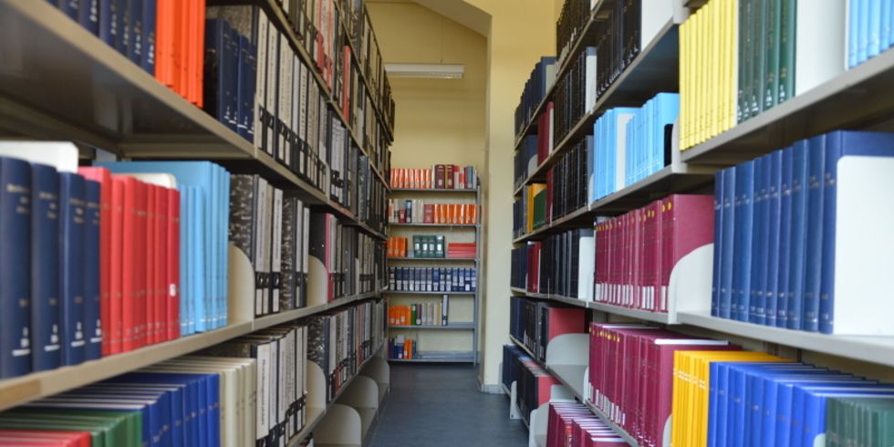 Gang zwischen Bücherregalen links und rechts mit vielen Büchern